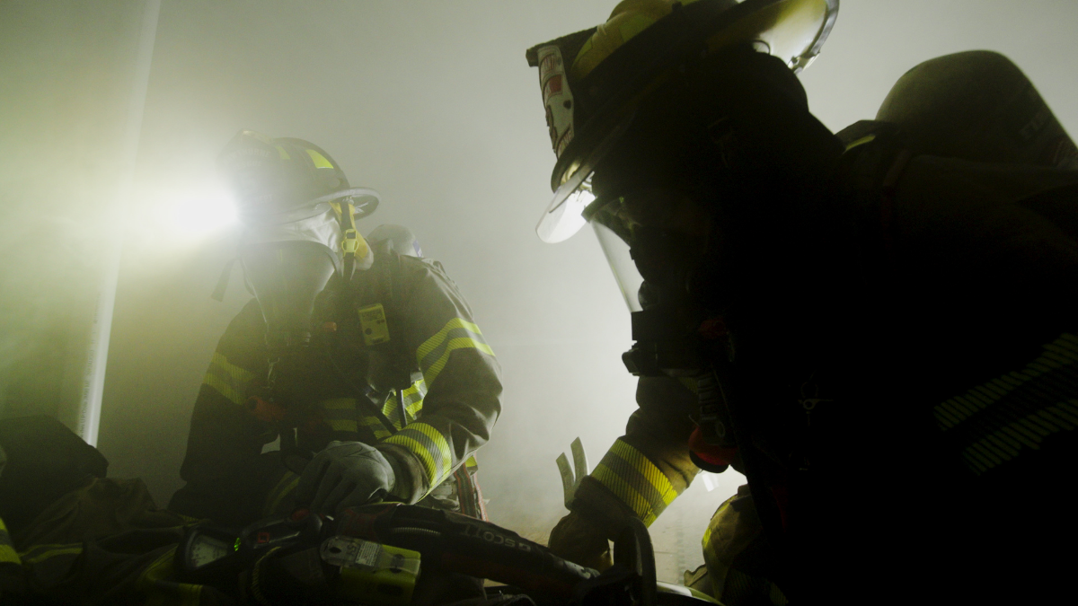 Firefighters operating in structural turnout gear during a live fire training exercise, illustrating the importance of breathable PPE that helps manage heat and moisture in demanding conditions.