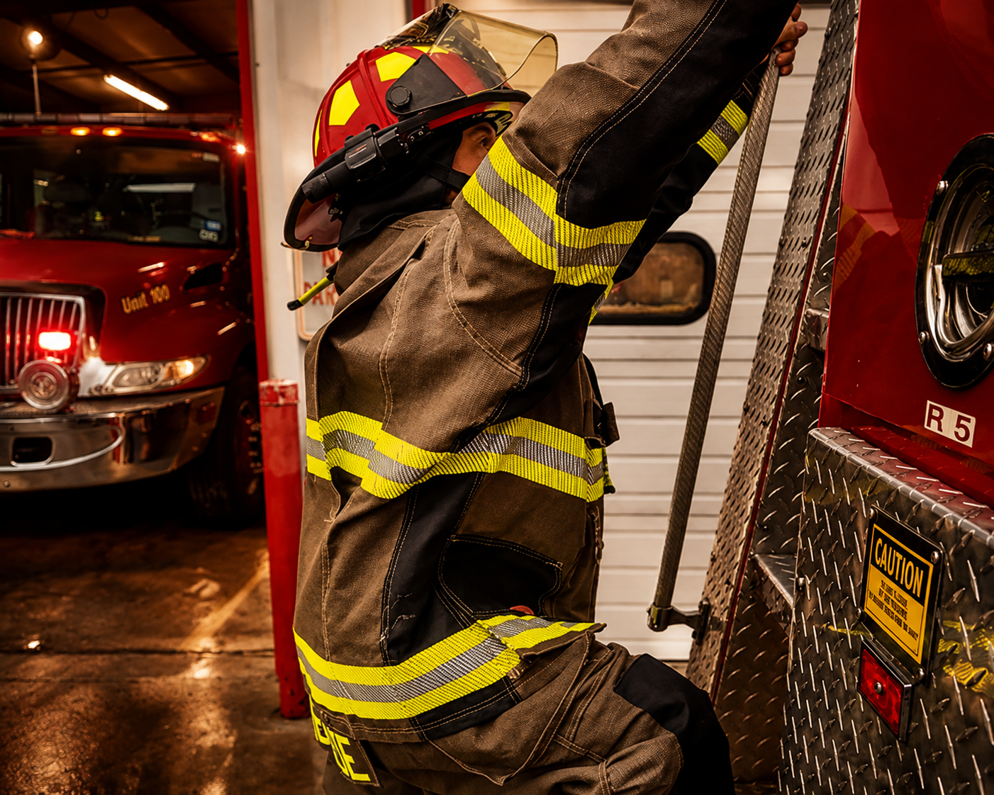 Firefighter demonstrating overhead reach in Ricochet Maximum Mobility turnout gear