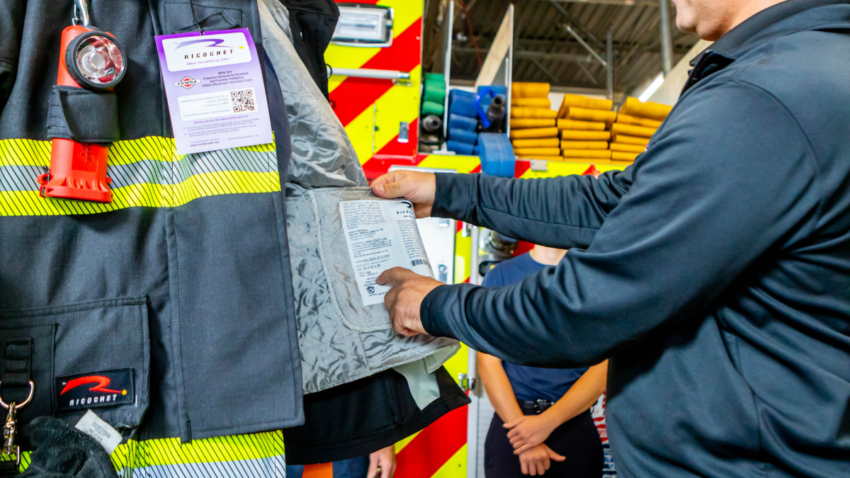 Ricochet representative demonstrating non-PFAS structural turnout gear features to firefighters during an in-station product evaluation.